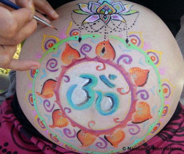 La photo d’un ventre rond de femme enceinte peint avec des dessins colorés pour un Blessing Way.